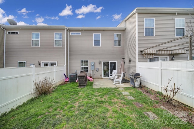 rear view of house with a patio, a yard, a fenced backyard, and cooling unit