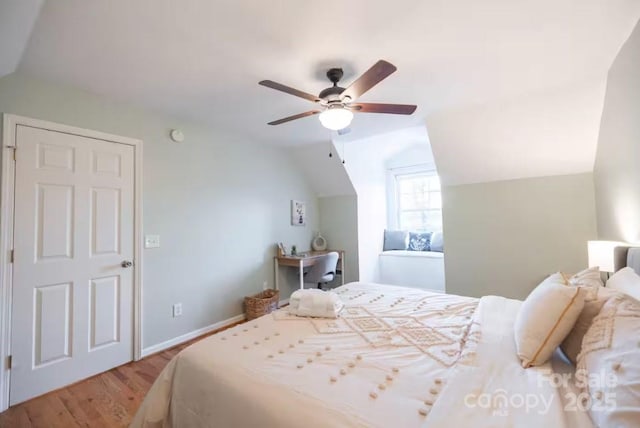 bedroom with lofted ceiling, wood finished floors, a ceiling fan, and baseboards