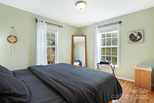 bedroom with light wood-style floors and baseboards