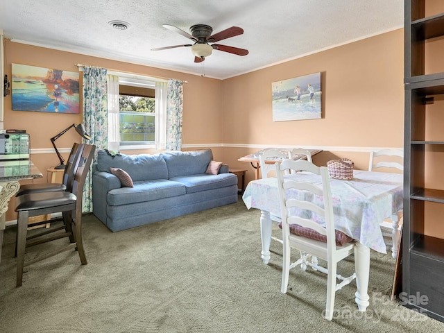 living room featuring visible vents, ceiling fan, a textured ceiling, crown molding, and carpet flooring