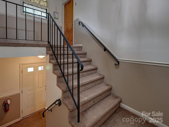 staircase featuring carpet and baseboards