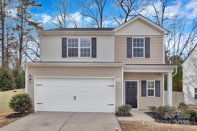 traditional home with a garage, fence, and concrete driveway