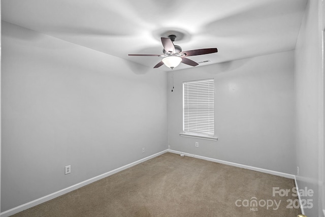 carpeted empty room with visible vents, baseboards, and ceiling fan