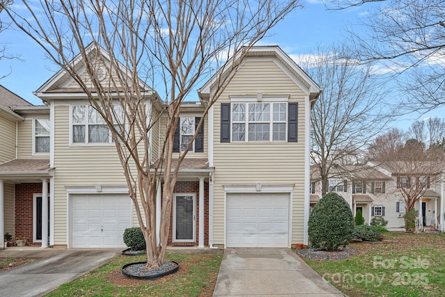 townhome / multi-family property with a garage, brick siding, and concrete driveway