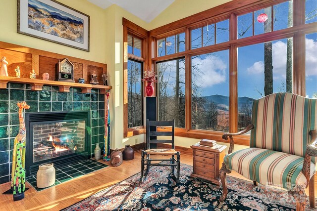 322 Crestview Dr, Black Mountain, NC 28711 - living room with a tiled fireplace, vaulted ceiling, wood finished floors, and a mountain view