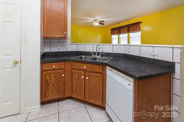 kitchen with brown cabinets, dishwasher, a peninsula, and a sink