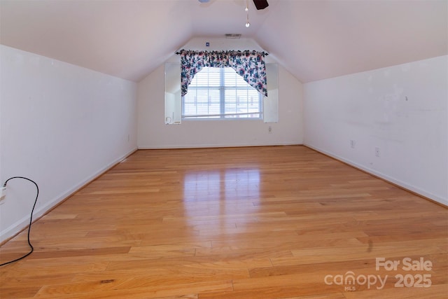 additional living space featuring baseboards, visible vents, a ceiling fan, lofted ceiling, and wood finished floors