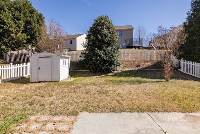 view of yard with a fenced backyard, an outdoor structure, and a storage unit