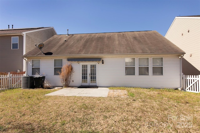 back of property with french doors, a patio, a lawn, central AC unit, and a fenced backyard