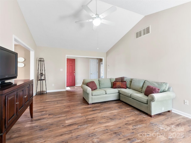 living room featuring high vaulted ceiling, wood finished floors, visible vents, and baseboards