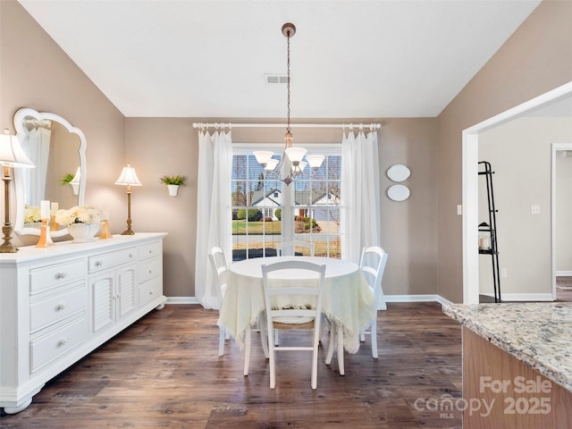 dining space featuring an inviting chandelier, baseboards, vaulted ceiling, and dark wood finished floors