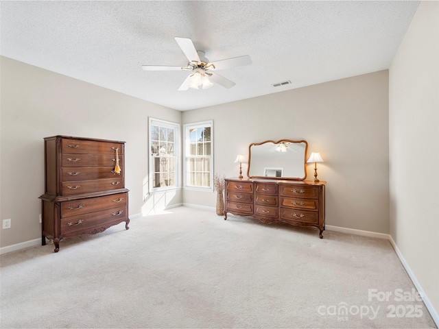 carpeted bedroom featuring a textured ceiling, a ceiling fan, visible vents, and baseboards