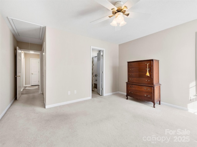 unfurnished bedroom with attic access, light carpet, and baseboards