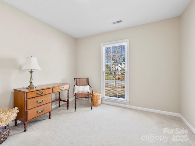 living area with baseboards, visible vents, and light colored carpet