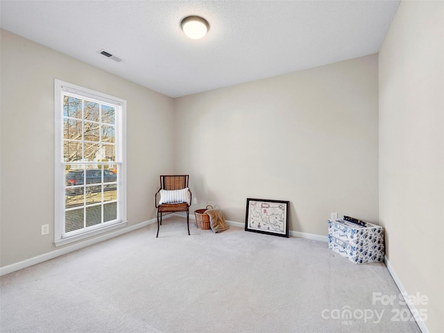 sitting room featuring a textured ceiling, carpet floors, visible vents, and baseboards