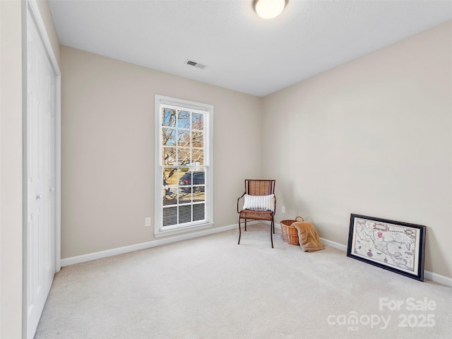 living area with carpet floors, visible vents, and baseboards