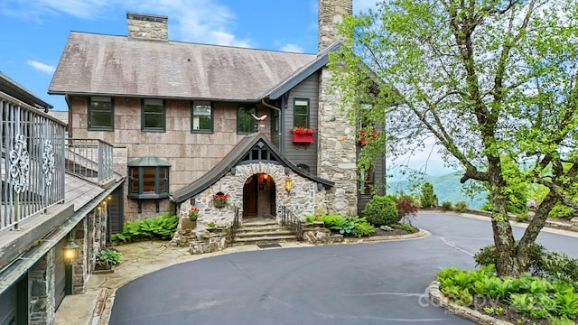 1245 Laurel Ln, Blowing Rock, NC 28605 - view of front of home featuring a chimney, stone siding, driveway, and a shingled roof