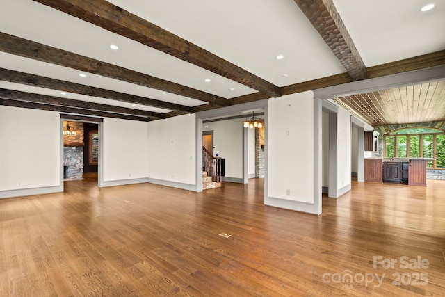 1245 Laurel Ln, Blowing Rock, NC 28605 - unfurnished living room with baseboards, beamed ceiling, wood finished floors, a chandelier, and stairs