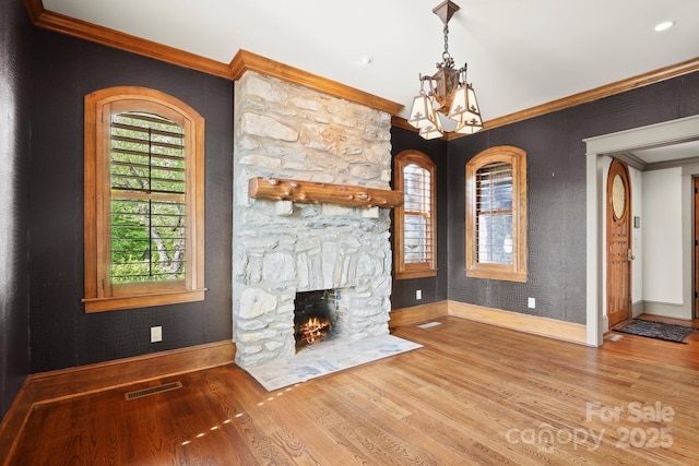 1245 Laurel Ln, Blowing Rock, NC 28605 - unfurnished living room featuring baseboards, wood finished floors, a chandelier, crown molding, and a stone fireplace