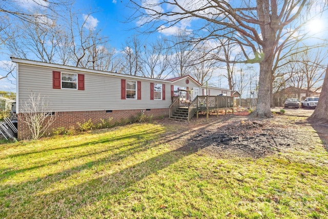 back of property with a deck, a yard, and crawl space