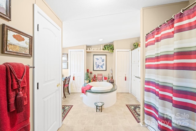 bathroom featuring vaulted ceiling and a shower with shower curtain