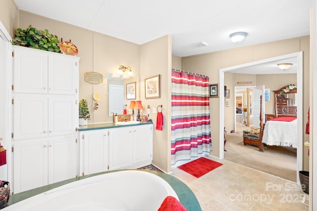 full bath featuring a washtub, curtained shower, vanity, and ensuite bathroom