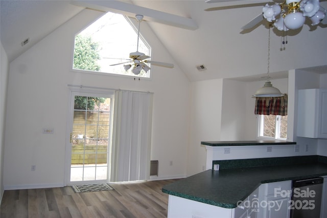 kitchen with dark countertops, dishwasher, visible vents, and wood finished floors