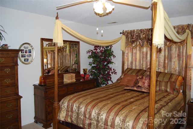 bedroom featuring carpet, visible vents, ceiling fan, and a textured ceiling