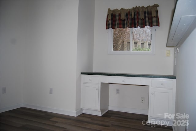 room details with electric panel, built in desk, baseboards, and wood finished floors