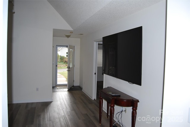 entrance foyer featuring a textured ceiling, baseboards, and wood finished floors