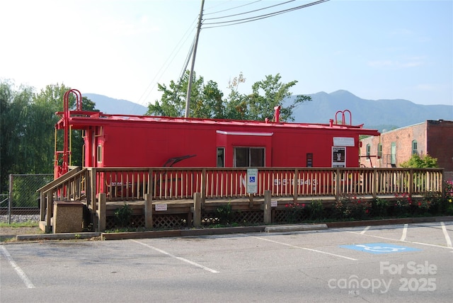 view of building exterior with uncovered parking and a mountain view