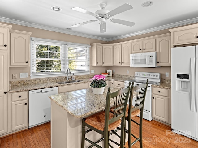 kitchen with ornamental molding, white appliances, light wood-type flooring, and a sink