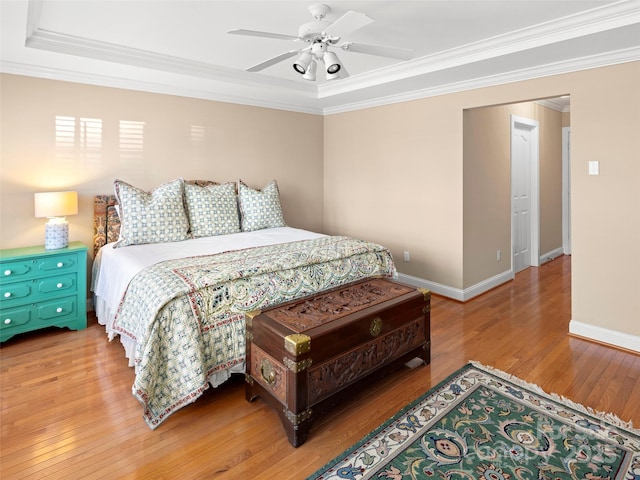 bedroom with wood-type flooring, crown molding, and baseboards