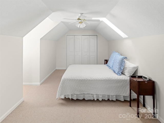 bedroom featuring ceiling fan, carpet flooring, baseboards, vaulted ceiling, and a closet