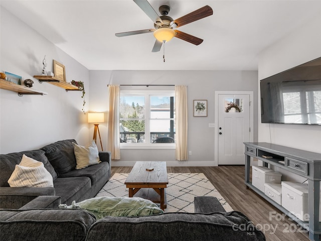 living room featuring ceiling fan, wood finished floors, and baseboards