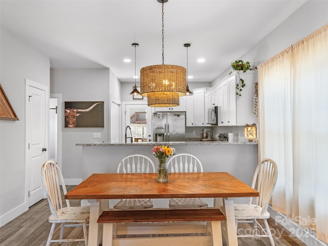 dining room with baseboards, wood finished floors, and recessed lighting