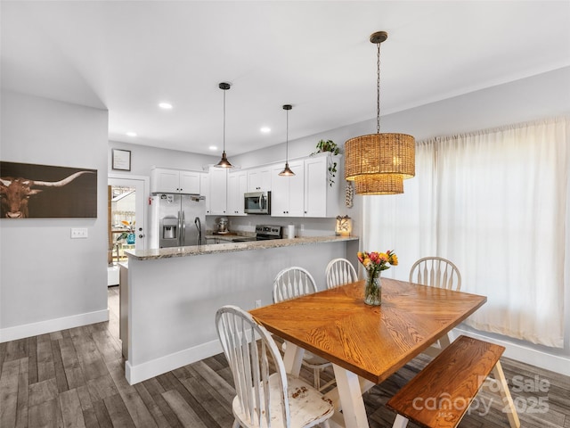 dining room featuring baseboards, dark wood finished floors, and recessed lighting