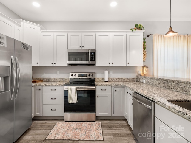 kitchen featuring appliances with stainless steel finishes, recessed lighting, white cabinetry, and light wood-style floors