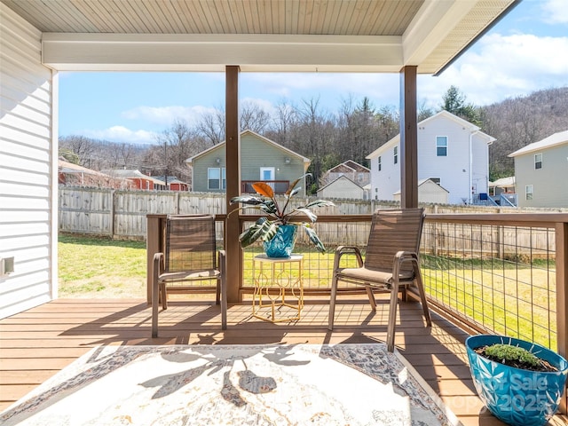 view of patio with a fenced backyard, a wooden deck, and a residential view