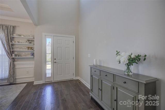 entrance foyer featuring ornamental molding, dark wood finished floors, and baseboards