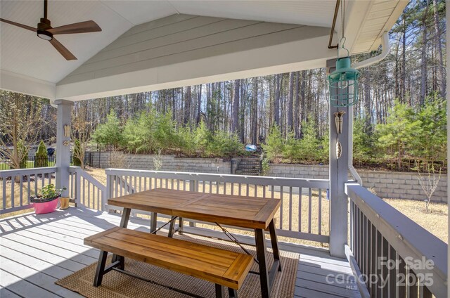 wooden deck with ceiling fan, fence, and outdoor dining space