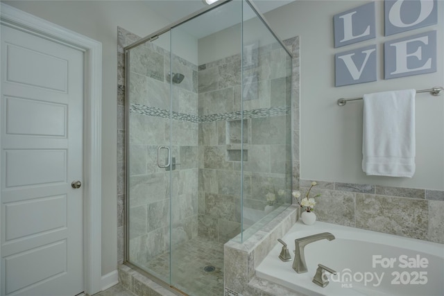 bathroom featuring a stall shower and a bath