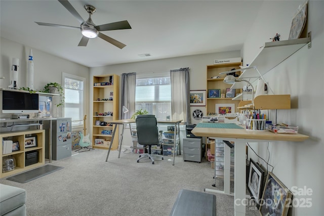 carpeted home office featuring plenty of natural light and a ceiling fan