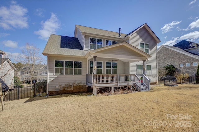 rear view of house with covered porch, ceiling fan, fence, and a lawn