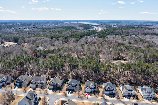 drone / aerial view featuring a forest view and a residential view