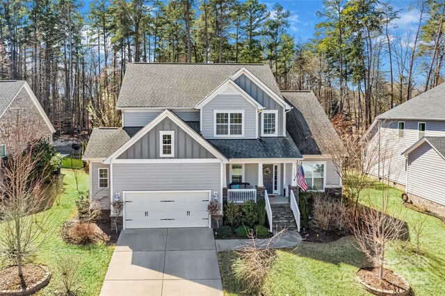 view of front of house featuring covered porch, roof with shingles, board and batten siding, and concrete driveway