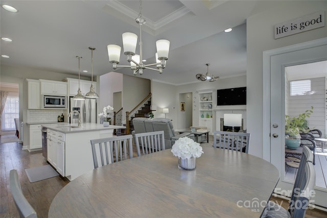 17609 Caddy Ct, Charlotte, NC 28278 - dining area featuring stairs, crown molding, dark wood finished floors, and a chandelier