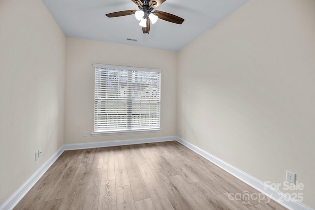 empty room with ceiling fan, wood finished floors, visible vents, and baseboards