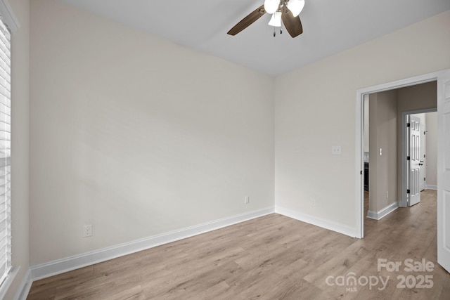 spare room with a ceiling fan, baseboards, and wood finished floors