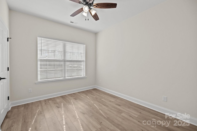 spare room featuring ceiling fan, light wood-style flooring, visible vents, and baseboards